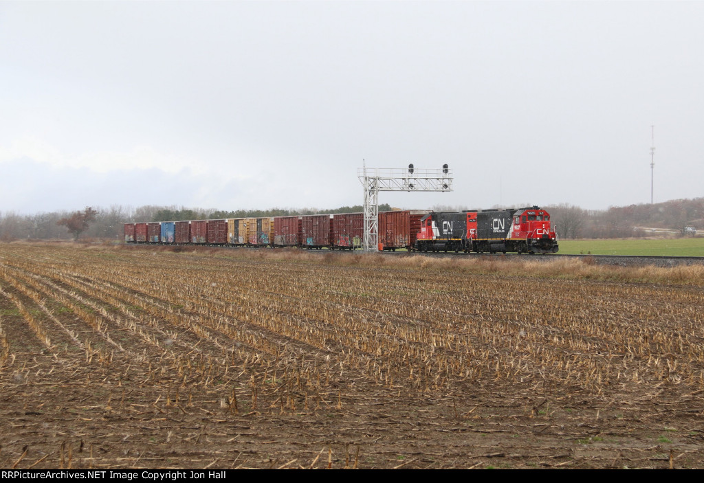 A pair of repainted IC GP38-2's pass under the southbound signals at Byron with cars for Quad Graphics